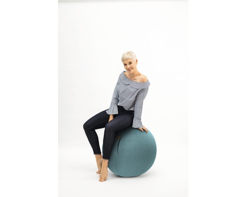 Frau sitzt auf einem Gymnastikball als Sitzgelegenheit.