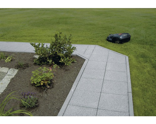 Gartenweg mit Pflastersteinen und Rasenroboter