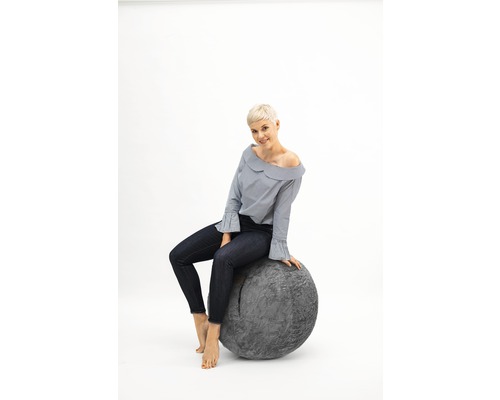 Frau sitzt auf einem grauen Sitzball