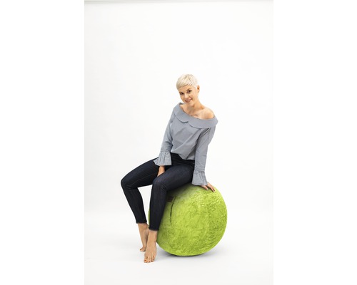 Frau sitzt auf einem grünen Sitzball