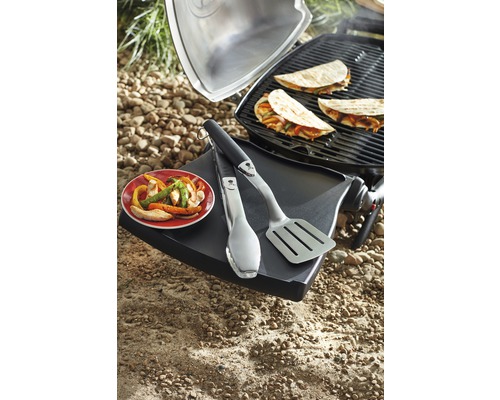 Grillszene mit Tacos, Grillzange und Pfannenspatel auf einem Grilltisch