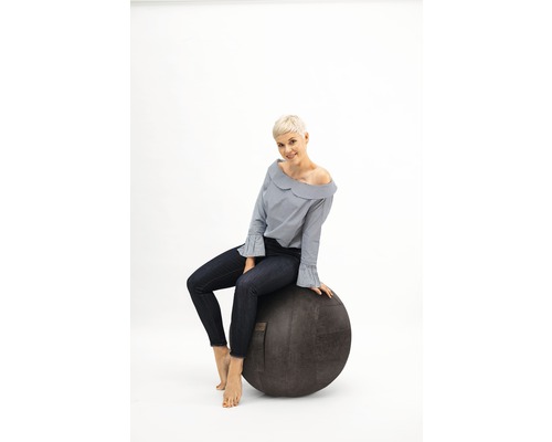 Frau sitzt auf einem Gymnastikball zur Fitness