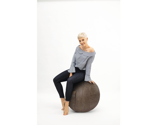 Frau sitzt auf einem Gymnastikball
