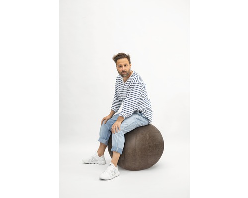 Mann sitzt auf einem Gymnastikball