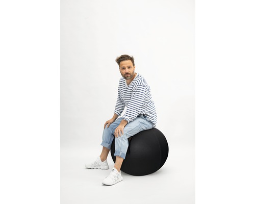 Mann sitzt auf einem Gymnastikball