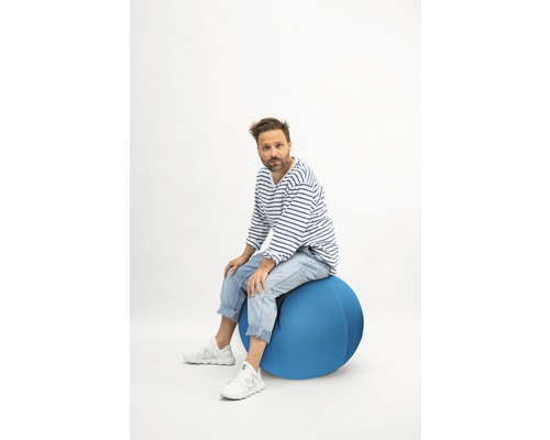 Mann sitzt auf einem Gymnastikball
