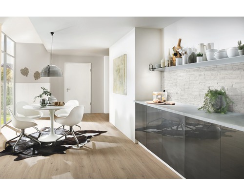 Helles Wohnzimmer mit Esstisch, Stühlen, Küchentheke und Wandgestaltung