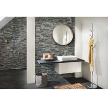 Badezimmer mit Waschtisch, Spiegel, Handtuchhalter und Steinwand