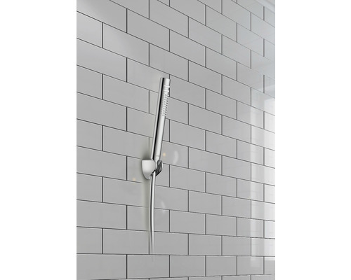 Handbrause mit Wandhalterung vor gefliester Wand