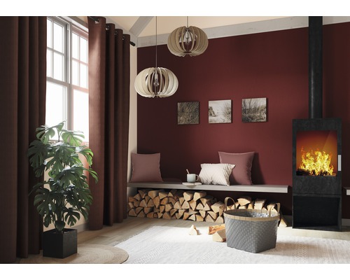 Wohnzimmer mit Kamin, Brennholz, Vorhängen und Zimmerpflanze