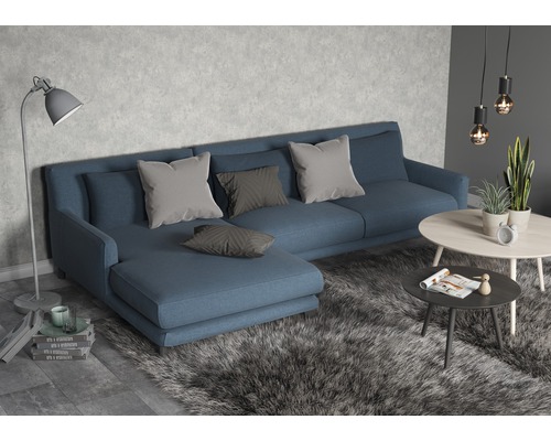 Wohnzimmer mit blauem Sofa, Kissen und Couchtischen auf einem Teppich