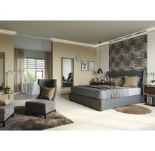 Schlafzimmer mit Bett, Sessel und Badewanne im Hintergrund