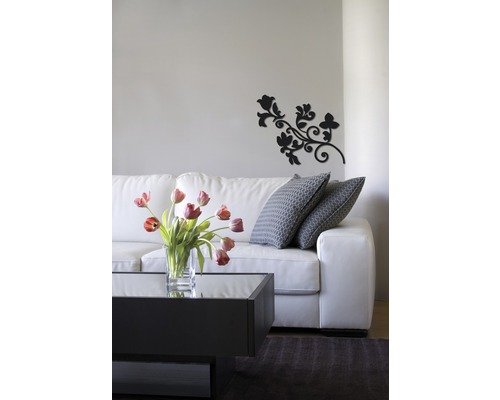 Wohnzimmer mit weißem Sofa, Couchtisch, Blumenvase und Wanddekoration