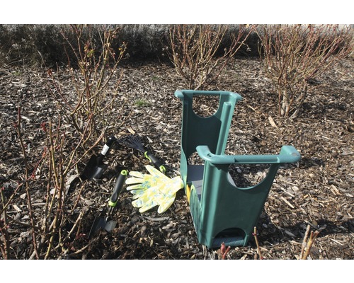 Gartenszene mit Kniebank, Gartenwerkzeugen und Gartenhandschuhen