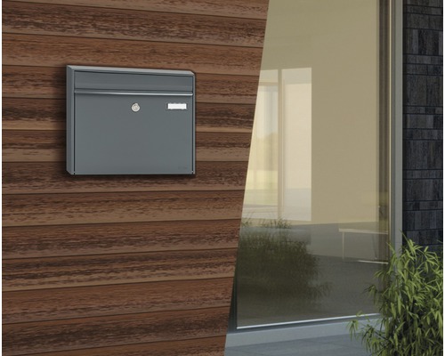 Grauer Briefkasten an Holzwand