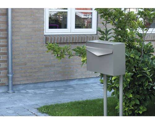 Briefkasten aus Metall auf zwei Pfosten im Vorgarten