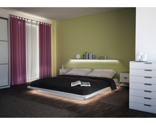 Schlafzimmer mit Bett, Nachttischen, Kommode und Vorhängen