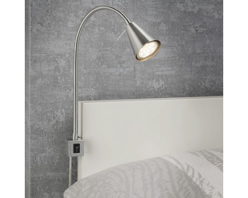Eine flexible, silberfarbene LED-Bettleuchte ist an einem weißen Bettrahmen befestigt.