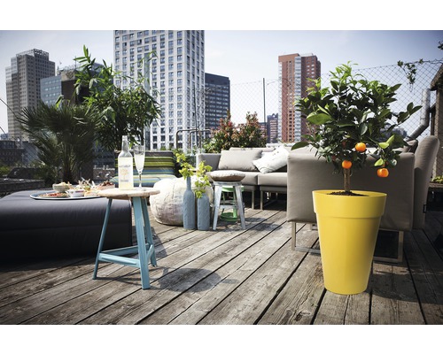 Terrasse mit Sitzgruppe, Tisch und Topfpflanzen vor Hochhaus