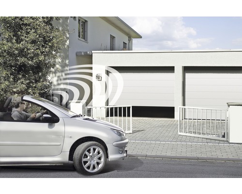 Person öffnet Garagentor per Funksignal vom Auto aus