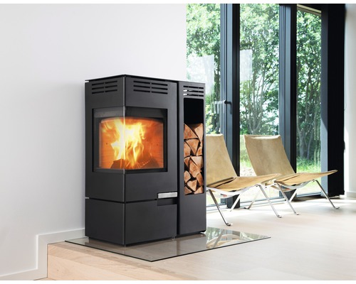 Moderner Kaminofen mit Holzscheitfach und Glasbodenplatte in einem hellen Raum.