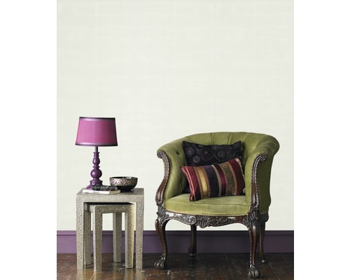 Innenaufnahme eines Wohnzimmers mit Sessel, Tisch und Lampe