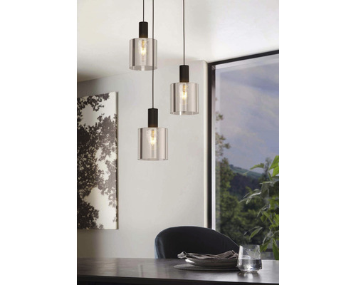 Drei Pendelleuchten aus Glas und Metall hängen über einem Esstisch