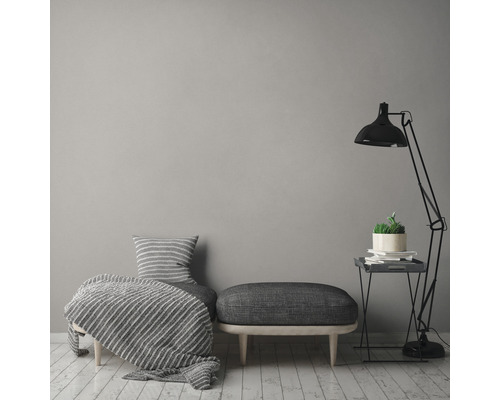 Wohnzimmer mit Sessel, Hocker, Stehlampe und Beistelltisch