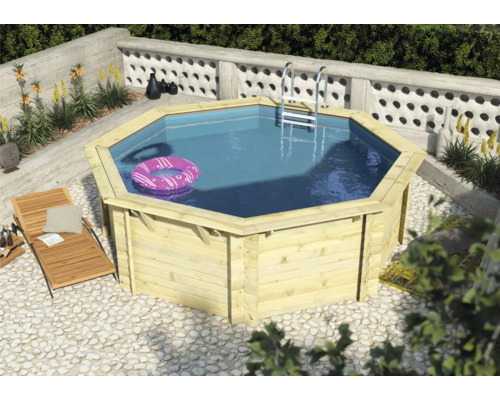 Achteckiger Holzpool mit Leiter und Luftmatratze im Garten.