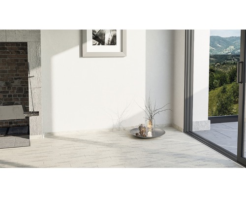 Heller Raum mit Fliesenboden, Bild an der Wand und Terrassentür mit Blick ins Grüne