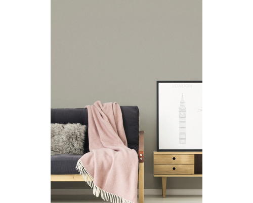 Wohnszene mit Sofa, Kissen, Decke, Kommode und gerahmtem London-Poster.