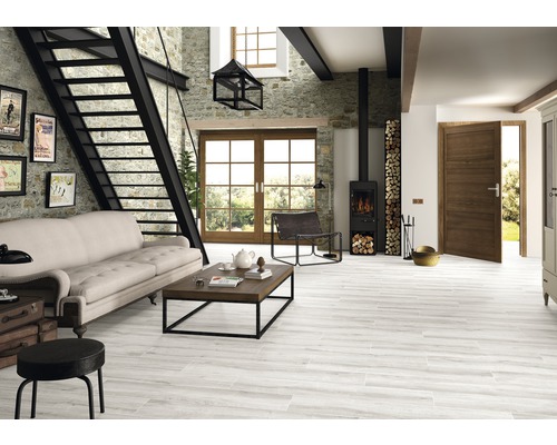 Helles Wohnzimmer mit Treppe, Kaminofen, Sofa und Holzbodenfliesen