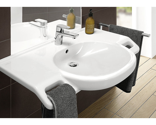 Waschtisch mit Armatur und Handtüchern im Badezimmer