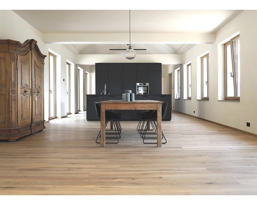 Heller Raum mit Holzboden, Esstisch, Stühlen und Küchenzeile