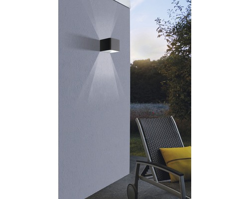 Kubische Außenwandleuchte aus Metall mit Lichtkegel an Hauswand