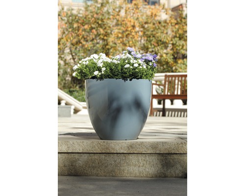 Blumentopf aus Kunststoff mit Blumen auf einer Steintreppe