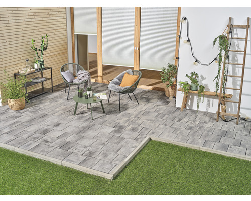 Terrasse mit Pflastersteinen, Gartenmöbeln und Dekorationen