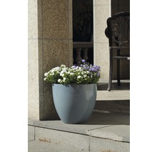Blumentopf aus Kunststoff mit Blumen auf einer Terrasse
