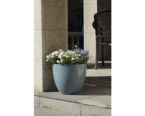 Blumentopf aus Kunststoff mit Blumen auf einer Terrasse