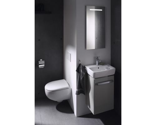 Modernes Badezimmer mit Wandtoilette, Waschtischunterschrank und beleuchtetem Spiegel