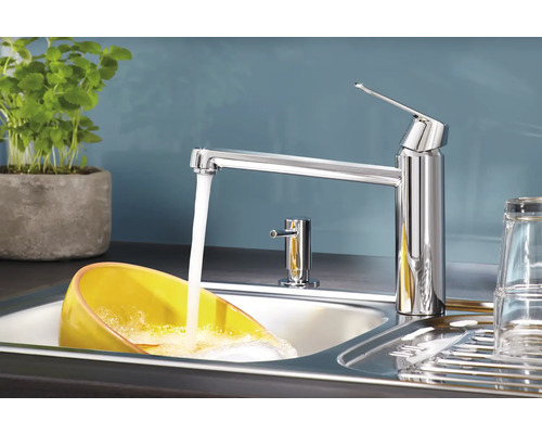 Spültischarmatur aus Chrom mit laufendem Wasser in einem Spülbecken