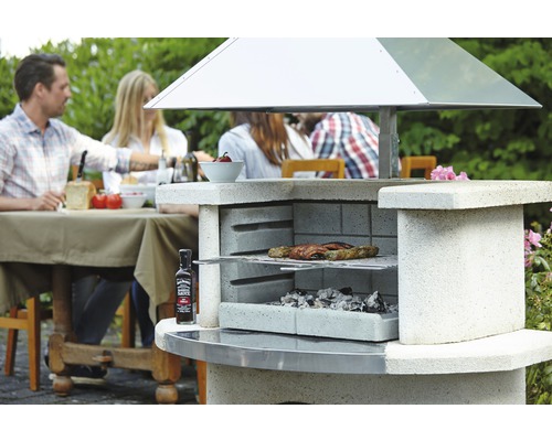 Gemauerter Gartengrill mit Grillgut und Personen im Hintergrund