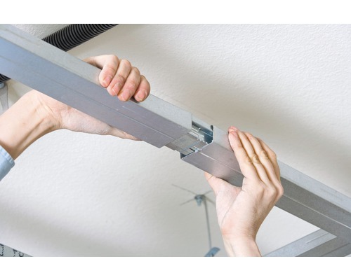 Person verbindet Trockenbauprofile für Deckenmontage