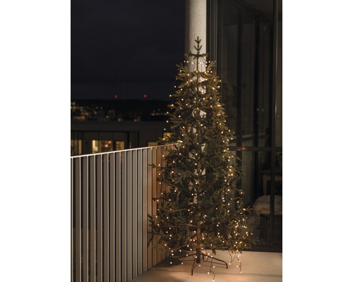 Geschmückter künstlicher Weihnachtsbaum auf einem Balkon.