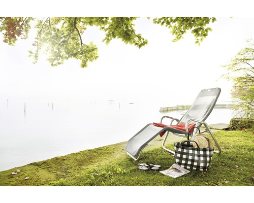 Szene mit Liegestuhl, Strandtasche und See im Hintergrund