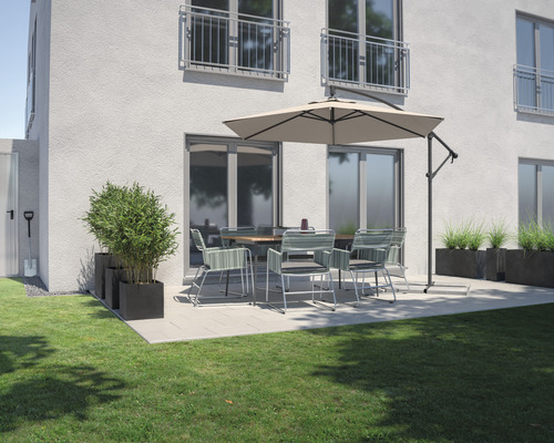 Gartenszene mit Esstisch, Stühlen, Sonnenschirm und Pflanzenkübeln auf einer Terrasse