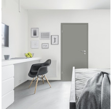 Modernes Zimmer mit Tür, Bett, Schreibtisch und Stuhl.