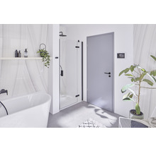 Helles Badezimmer mit Badewanne, Dusche und grauer Tür