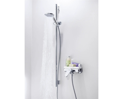 Duscharmatur mit Brausestange und Ablage mit Pflegeprodukten im Badezimmer