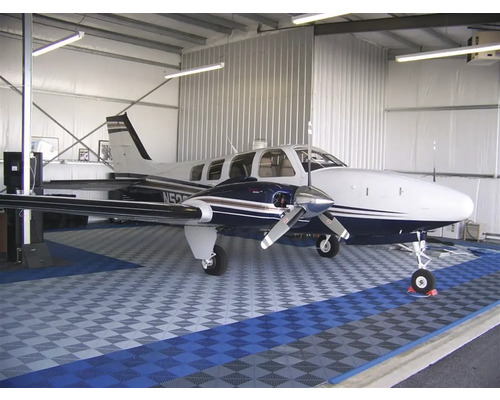 Flugzeug in einem Hangar mit Bodenfliesen.
